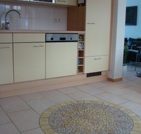 Keuken met zon van moziëk in vloer verwerkt
