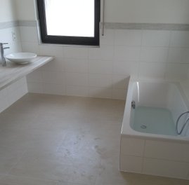 Badkamer met bad en wastafel